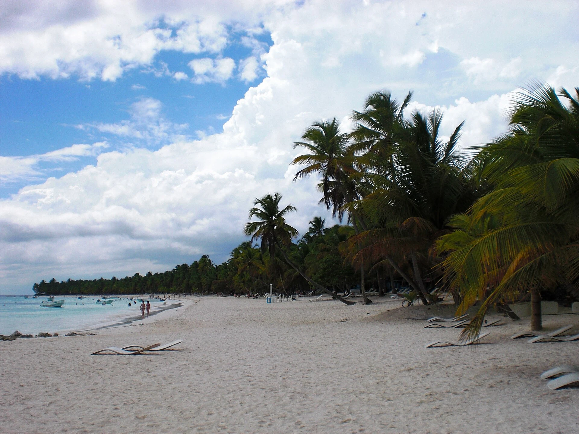Una spiaggia di sabbia bianca a Saona sotto palme da cocco e un cielo nuvoloso