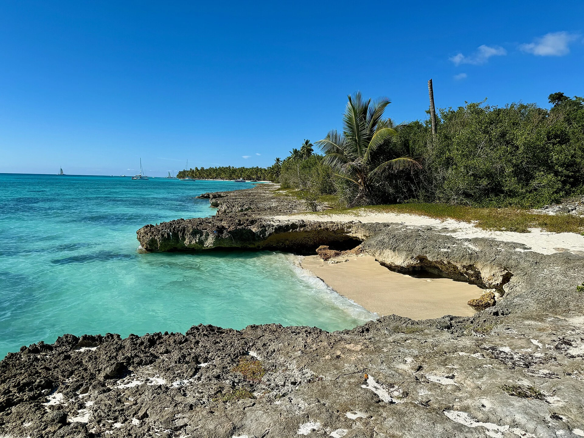 Un’insenatura turchese bassa bordata di sabbia chiara e roccia sulla costa di Saona
